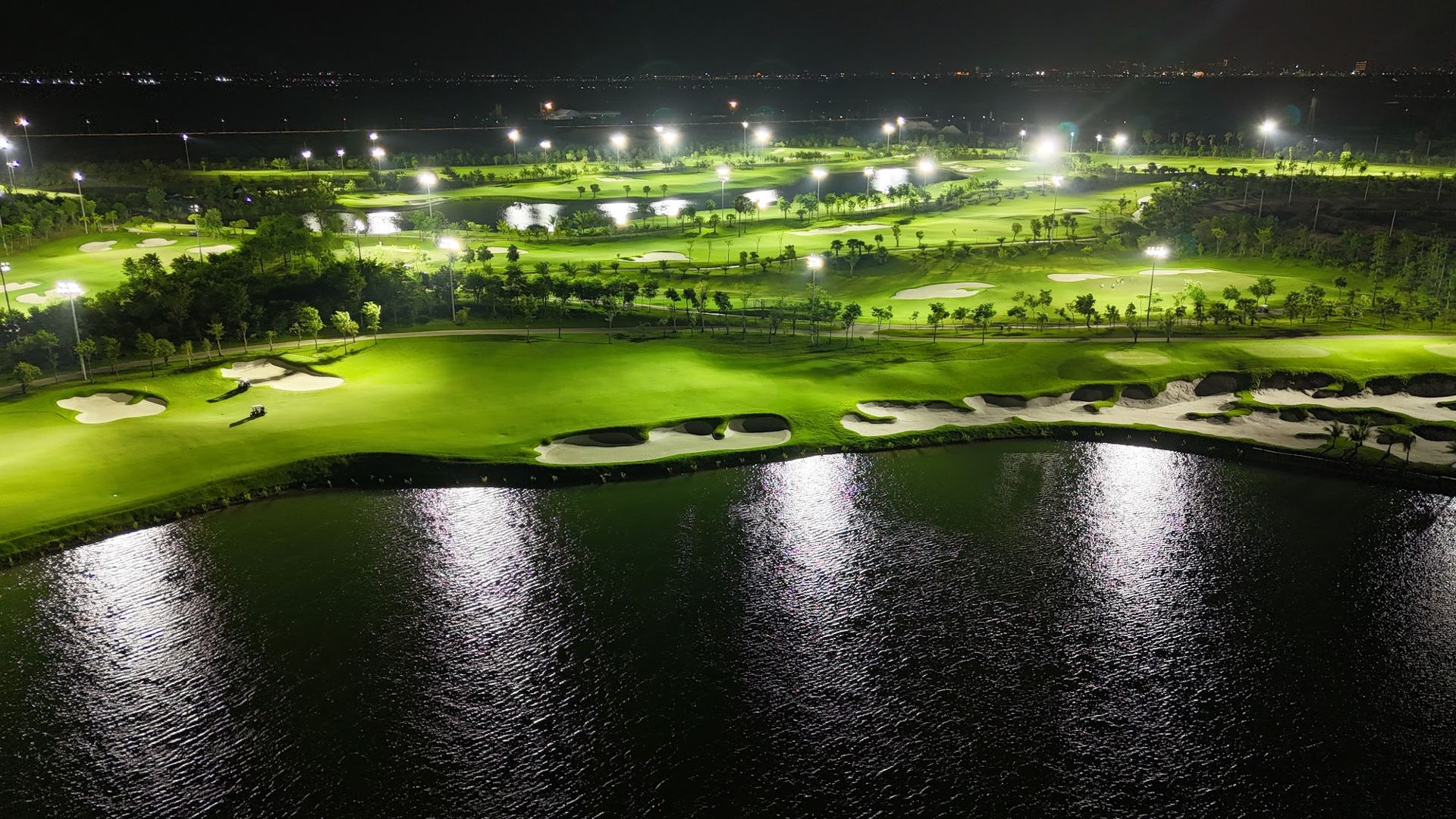 Floodlit fairway mirrored in the lake